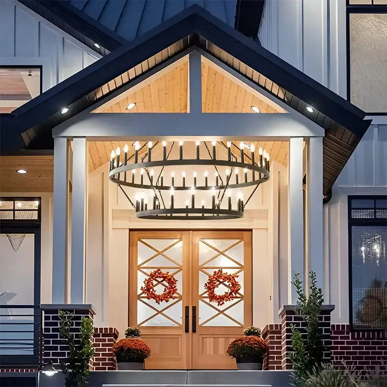 Black wrought iron decorbites™ vintage modern led pendant chandelier with candle-style lights above wooden front door