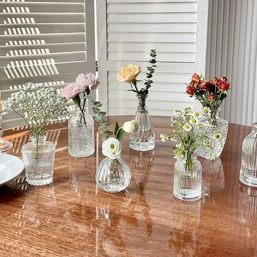 Clear glass vintage relief vases with intricate etched patterns holding delicate flowers for hydroponic plants