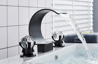 DecorBites™ waterfall bathroom basin faucet in black with crystal-like knobs and a curved waterfall spout for hot and cold mixing