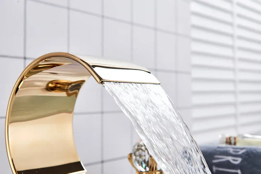 Gold-colored sleek waterfall bathroom basin faucet with modern curved design by decorbites hot cold mixer