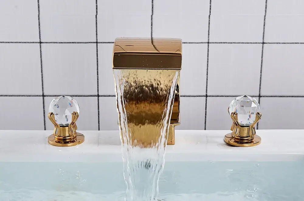 Gold-toned decorbites™ waterfall bathroom basin faucet with crystal handles and sleek modern design for hot cold mixer
