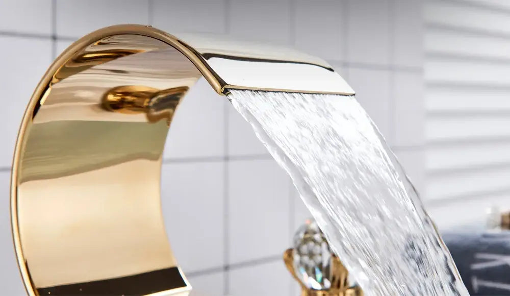 Gold-toned waterfall bathroom basin faucet by decorbites with sleek curved design and polished metallic finish for hot cold mixer