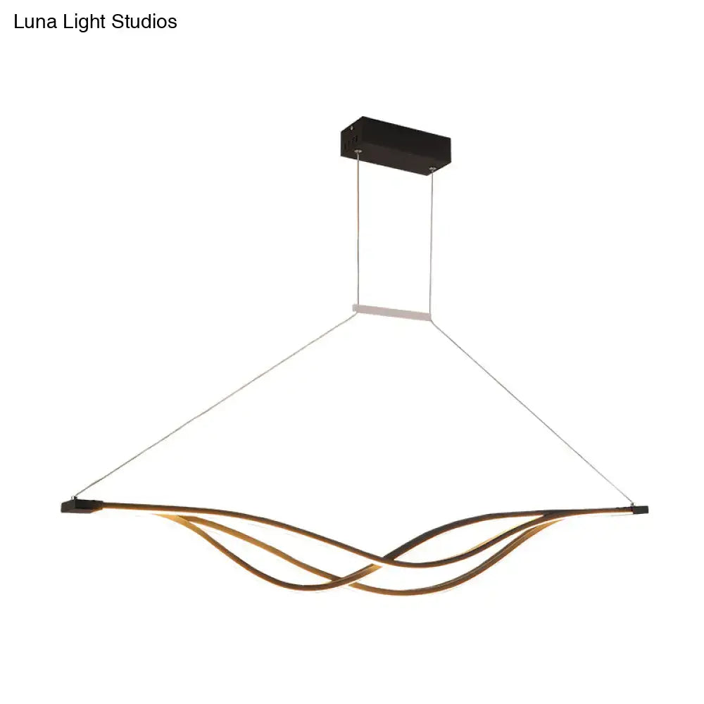 Modern gold-toned wave shaped metal LED island light fixture with sleek design and black rectangular ceiling mount