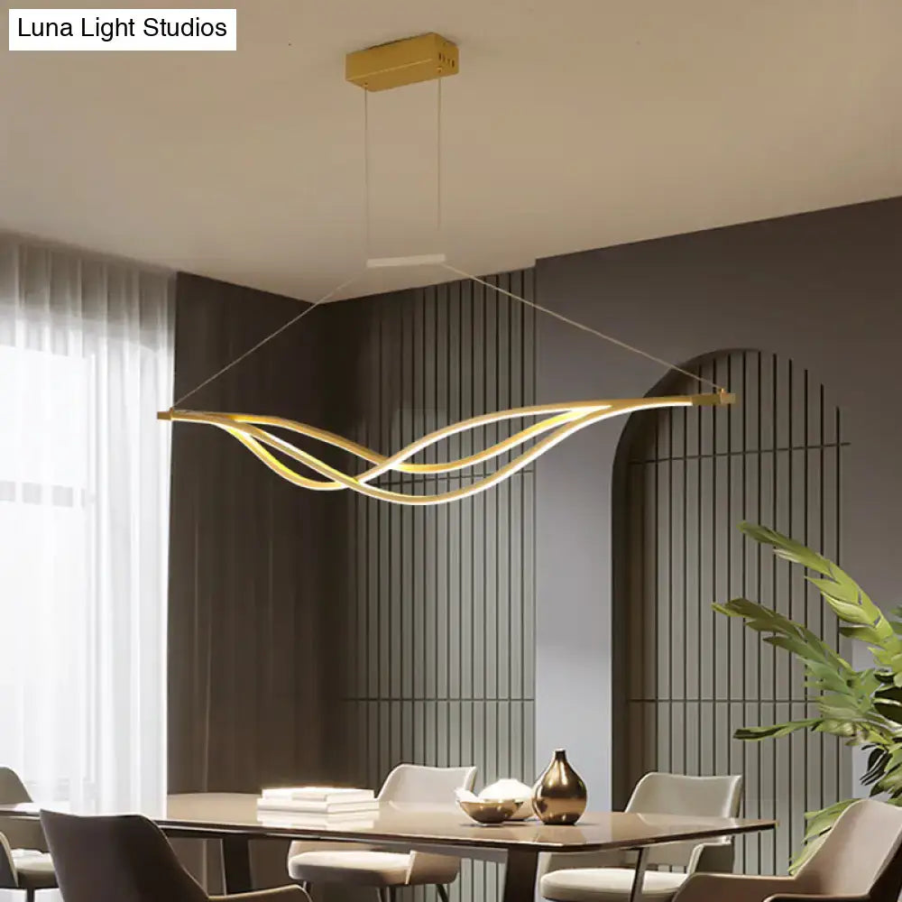 Gold-colored wave shaped metal led island light fixture with minimalist suspension for dining room by DecorBites
