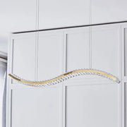 A sleek gold-toned DecorBites™ wavy k9 crystal LED dining room pendant light with embedded clear crystals and remote control