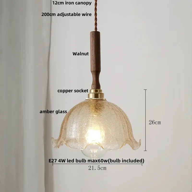 A warm amber glass pendant light with a textured petal design and walnut wood handle paired with white ceramic led accents