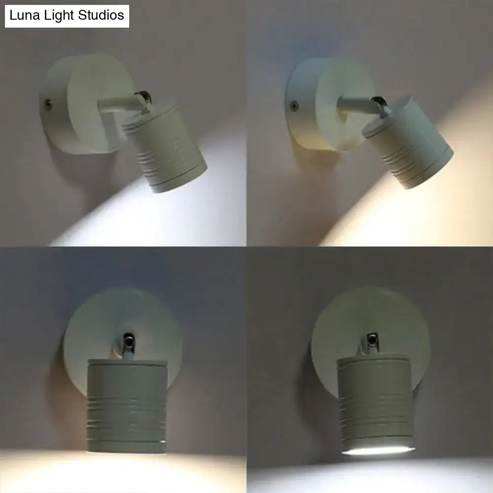 Off-white cylindrical wall sconce lamp with textured ribbed head and circular base providing warm white light