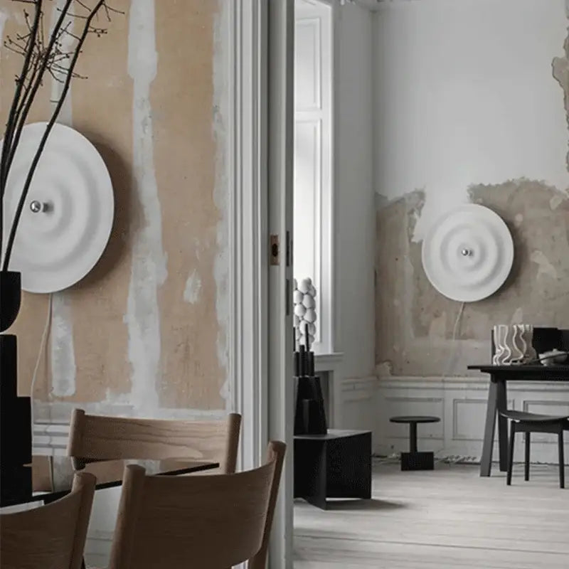 White nordic bauhaus round wall sconce with concentric rings and central metallic fixture in a bauhaus round lamp design
