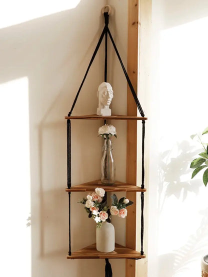 Black macrame cord suspends three wooden triangular shelves in the DecorBites wooden corner shelf boho wall decor