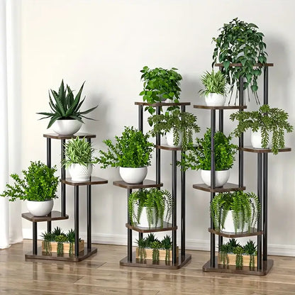 Set of three tiered decorbites wooden plant stands with dark brown shelves and black metal frames holding green plants