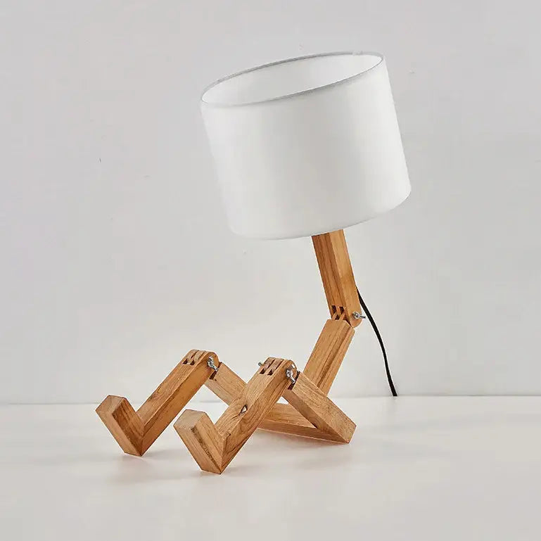 Minimalist wooden robot shape table lamp with white cylindrical shade and articulated legs for indoor study use