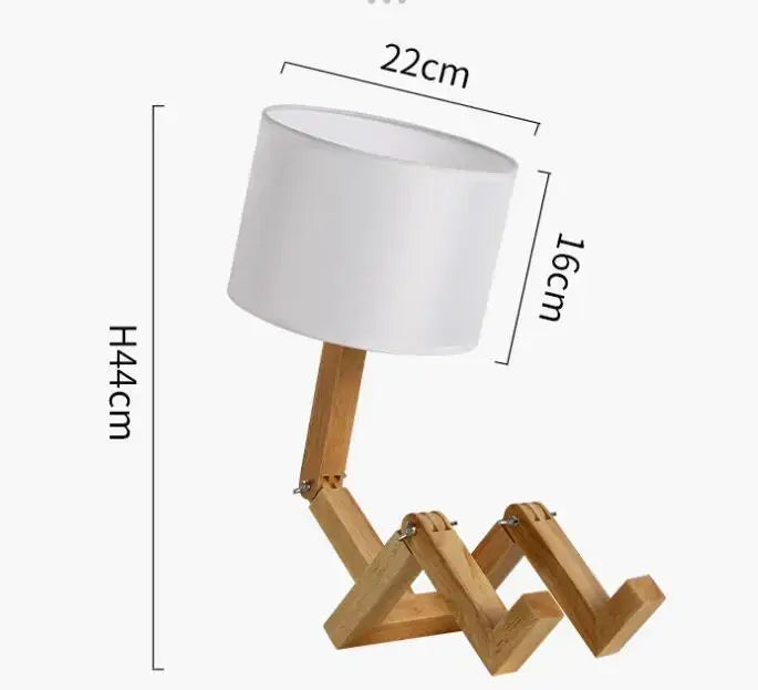 A minimalist decorbites wooden robot shape table lamp with white cylindrical shade and articulated zigzagging legs