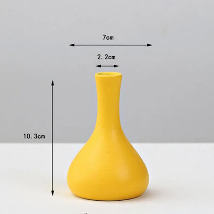 A sleek matte yellow porcelain flower vase with a slender neck and rounded base for home decor by decorbites
