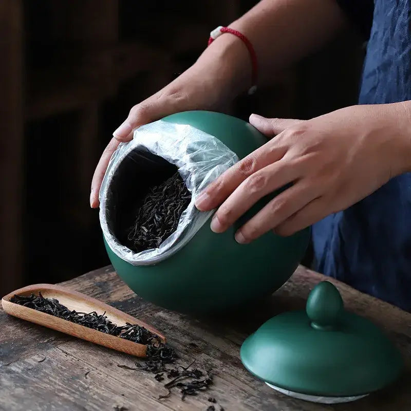 Matte deep green ceramic tea caddy jar with rounded body and smooth surface for kitchen storage
