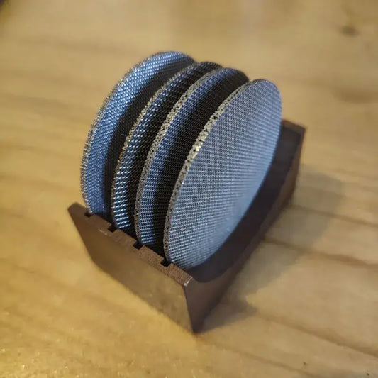 Set of four denim blue and black coasters with espresso puck screen in a wooden holder for decorbites espresso puck use