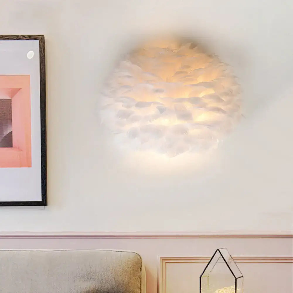 Designer feather white and grey wall sconce with soft feathers and warm glow as a bedroom wall lamp
