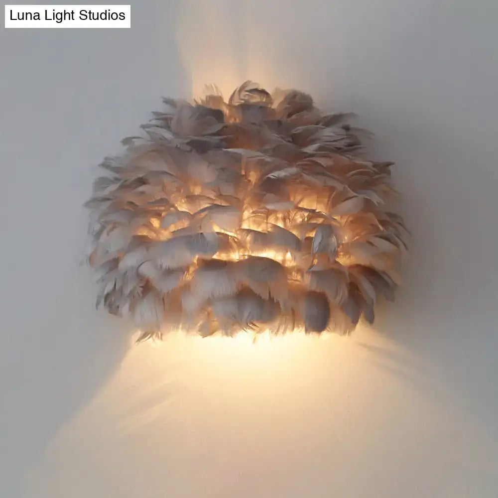 Designer feather white and grey wall sconce wall lamp with layered natural feathers glowing softly for bedroom use