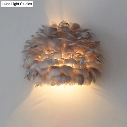 Designer feather white and grey wall sconce wall lamp with layered natural feathers glowing softly for bedroom use