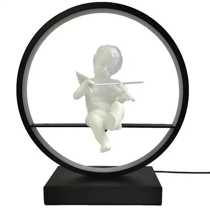 White cherub figurine playing flute inside black frame on dimmable angel table lamp by decorbites for bedroom decor
