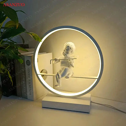 Dimmable angel table lamp featuring a white ceramic cherub suspended in a circular led light frame for decorbites decor