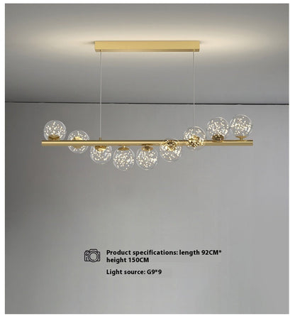 Gold linear dining room chandelier with glass globe accents and modern design as creative 3d long light source