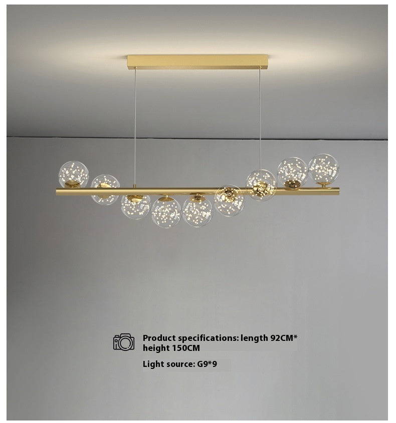 Gold linear dining room chandelier with glass globe accents and modern design as creative 3d long light source