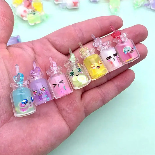 A hand holds diy heart pearl shell miniature wishing bottles with colorful liquid and cartoon faces for bedroom decor