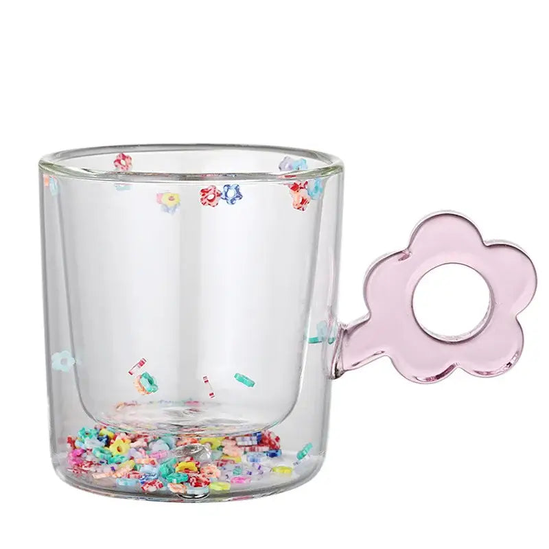 Double wall glass mug with a clear design pink flower-shaped handle and colorful glitter flowers inside for dining room use