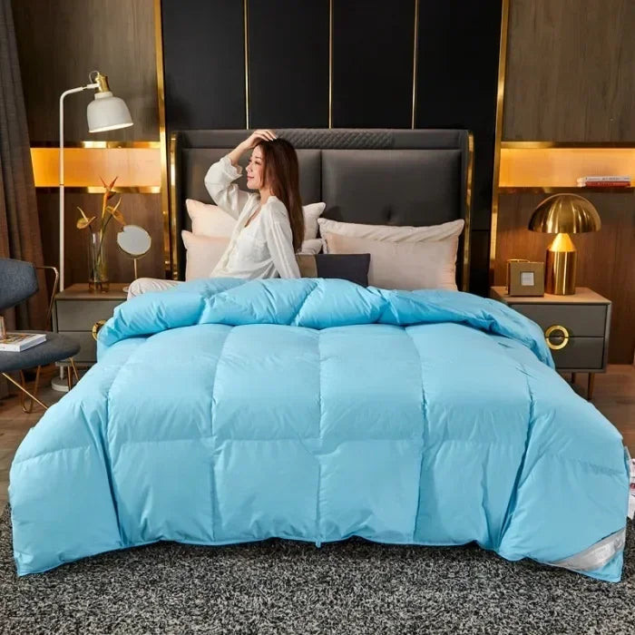 Light blue quilted down duvet with soft plush texture and square stitching made of 95 white goose down