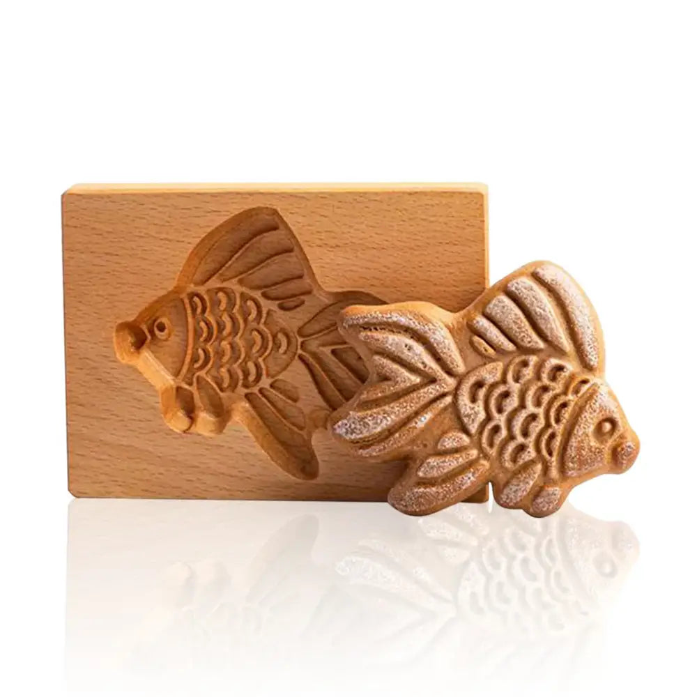 A golden-brown fish-shaped gingerbread cake pressed from a light wood gingerbread cake wooden mold decorbites