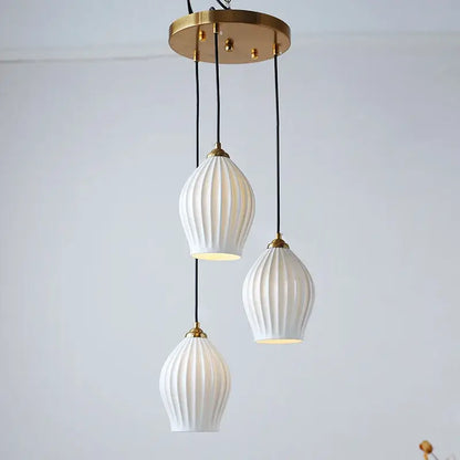 Elegance ribbed ceramic pendant lights in white with gold-toned metal accents and black cords for dining room lighting