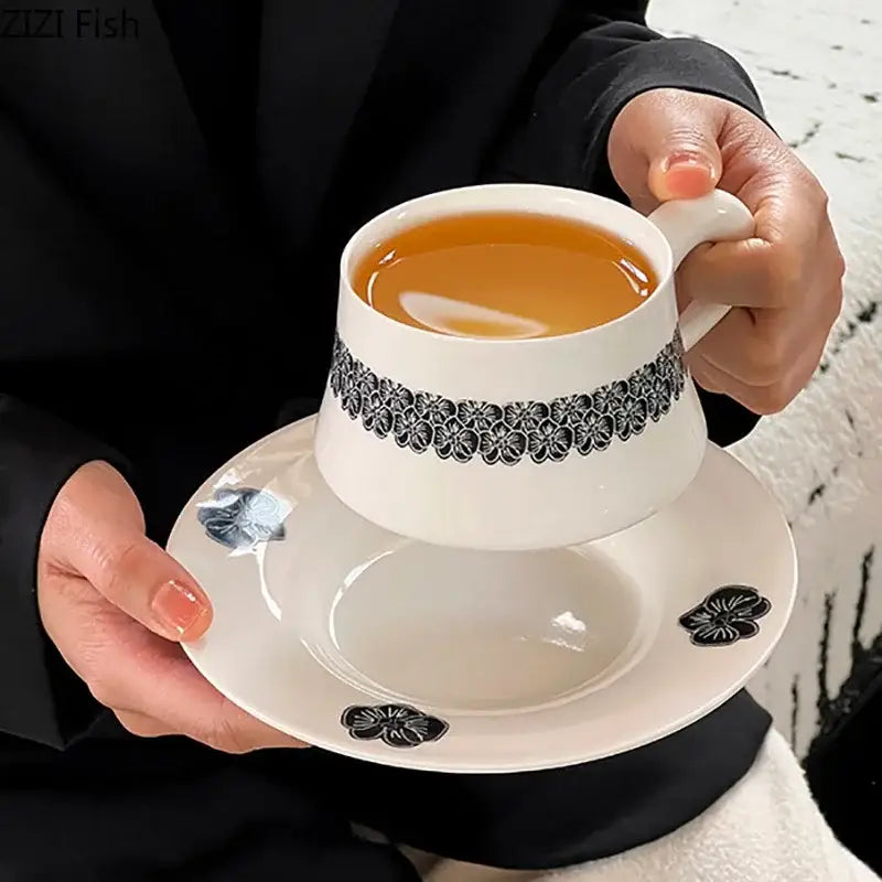 Elegant black and white floral porcelain cup and saucer set featuring a white ceramic design for dining room use