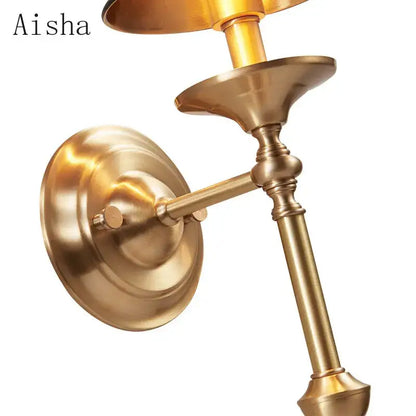 Brass-finished aisha wall sconce with fluted details and curved arm in decorbites black gold wall lamp for bedroom decor