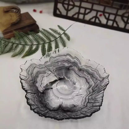 A translucent glass plate with black and gray marbled pattern and organic leaf-like rim from decorbites elegant flower collection