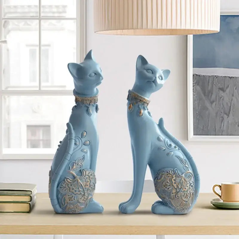 Two light blue ceramic decorbites cat statues with intricate gold floral detailing for elegant living room decor