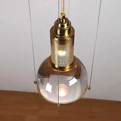 Elegant brass pendant lights with a clear glass dome and perforated metal cage for dining room decorbites crystal ball led