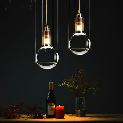 Two elegant brass pendant lights with clear crystal ball led glass globes hang for dining room decorbites crystal ball