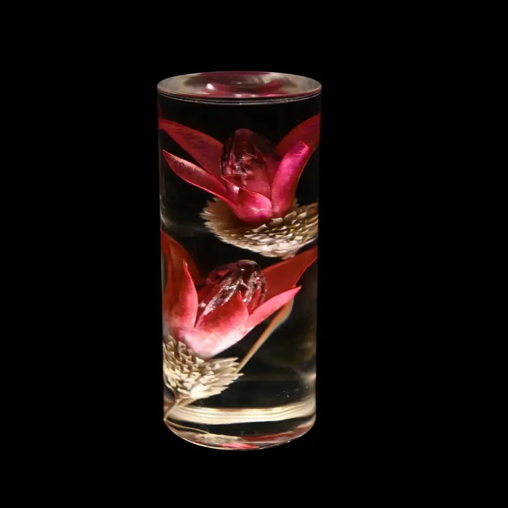 Elegant brass decorbites eternal flower desk lamp featuring a cylindrical glass vessel with preserved red flowers and golden seed heads in clear liquid