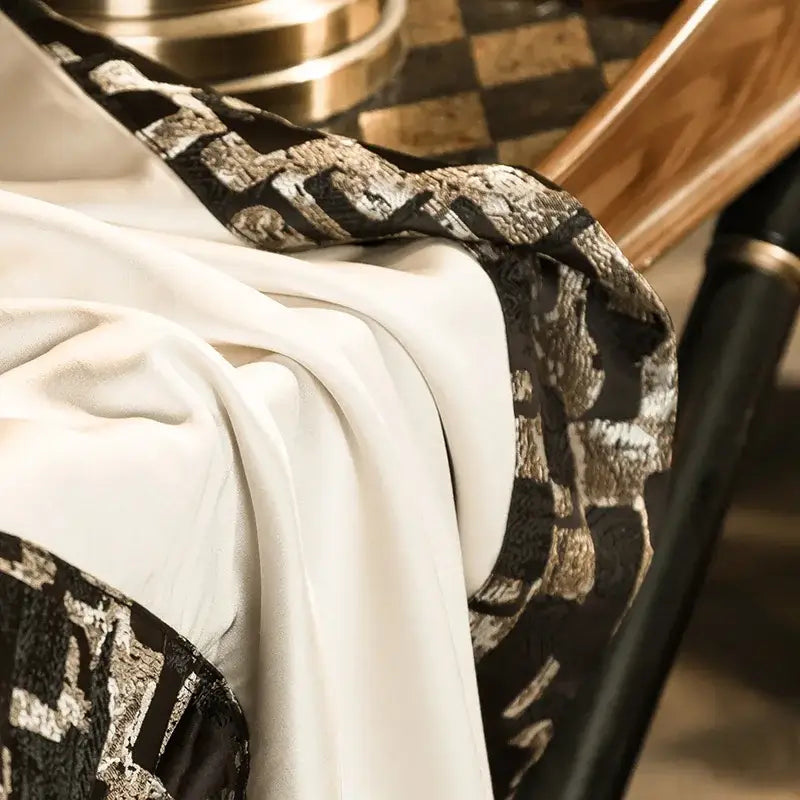 A luxurious white silk scarf with black and gold geometric pattern complements the elegant 200s embroidery egyptian cotton bedding set