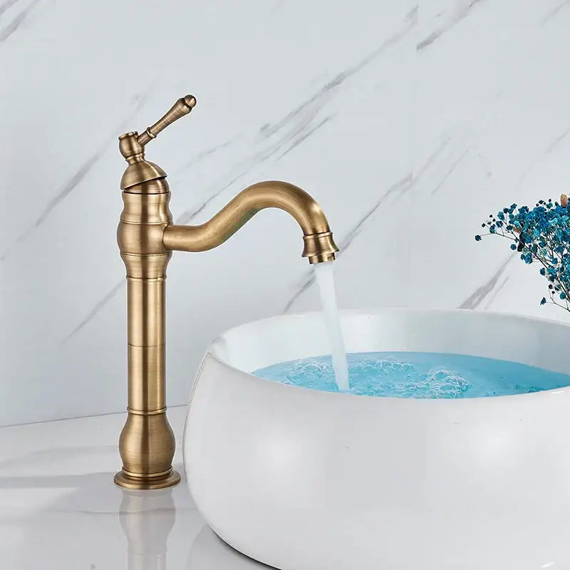 Antique brass finished single handle sink faucet with curved spout and ornate detailing for bathroom use