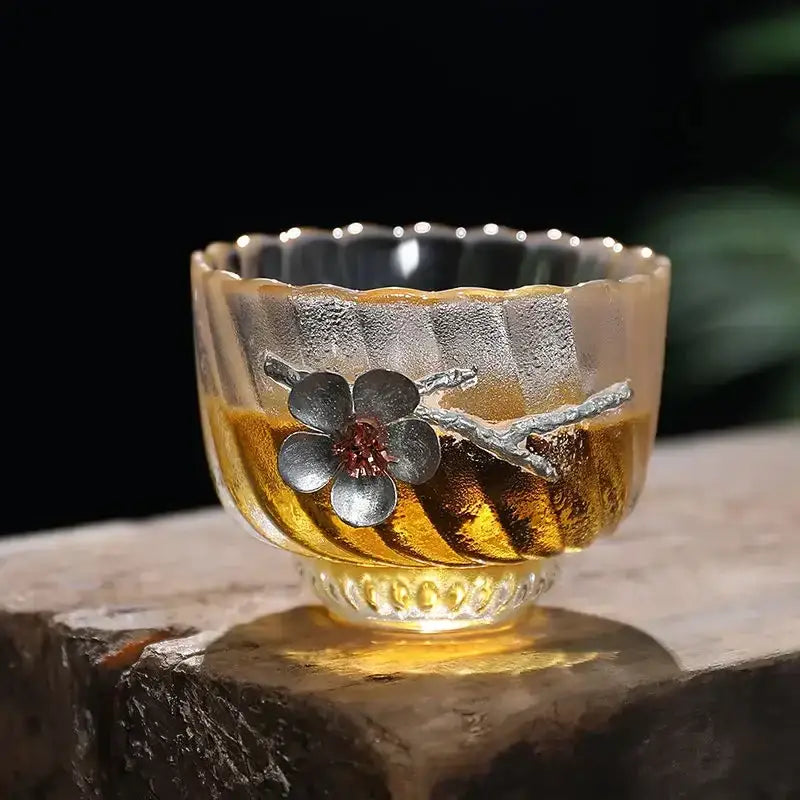 Elegant carved tin glass tea cup set featuring a translucent amber glass tea cup with silver-plated cherry blossom design