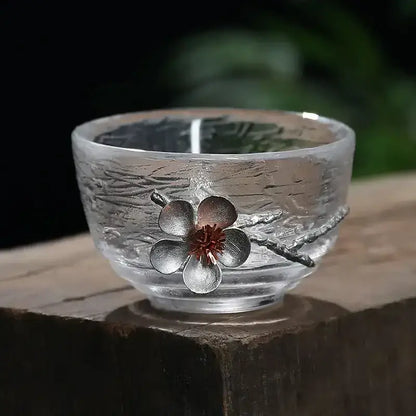 Elegant carved tin glass tea cup set featuring clear textured glass and ornate silver flower accent with red center