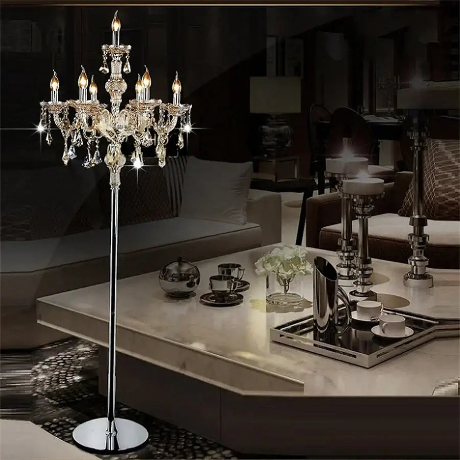 Elegant chrome crystal floor lamp with multiple lit candle LED style bulbs and dangling crystal droplets for living room decor