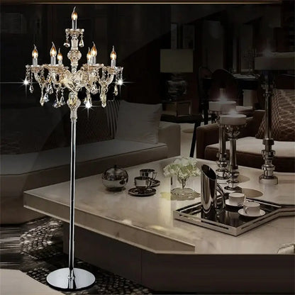 Elegant chrome crystal floor lamp with multiple lit candle LED style bulbs and dangling crystal droplets for living room decor