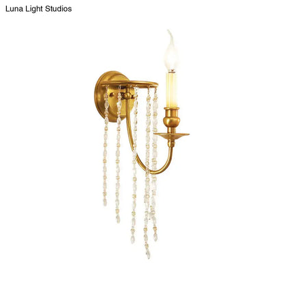 Elegant crystal chain gold wall sconce light fixture featuring a gold-toned candle bulb and cascading clear crystal beads