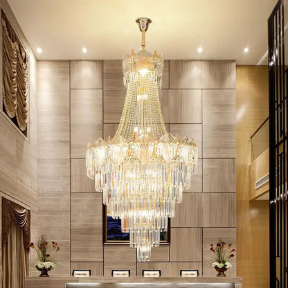 Elegant crystal duplex chandelier with cascading clear and gold glass prisms suspended from polished brass decorbites elegant crystal fixture