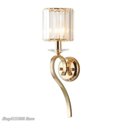 Elegant crystal gold wall lamp featuring a gold-toned wall sconce with cylindrical crystal shade and curved metal arm