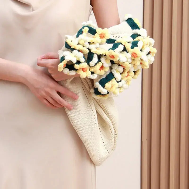 A chunky crocheted floral clutch in cream yellow and green accents inspired by decorbites elegant daisy bouquet soft design