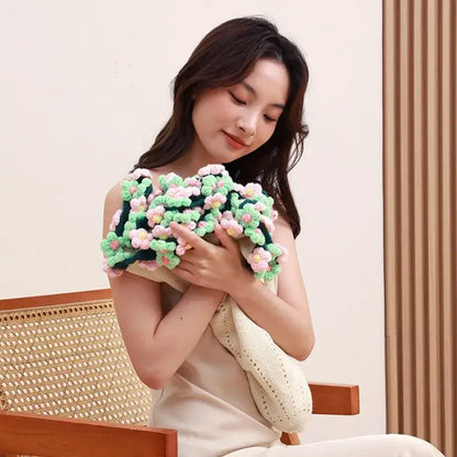 Elegant daisy bouquet crocheted clutch bag with vibrant green and pink floral patterns on a soft beige base