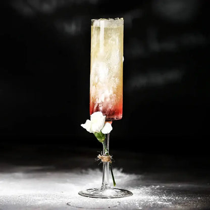 A slender bubble champagne glass filled with a red to pale yellow layered cocktail from decorbites set of 2